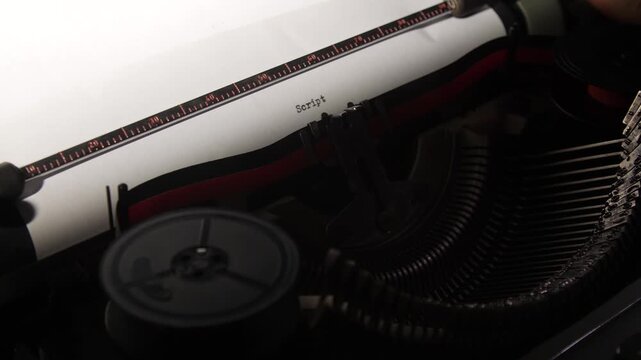 Vintage typewriter typing the word script onto a white piece of paper, emphasizing the creative process of writing, storytelling, and old fashioned media