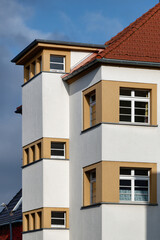 Facade detail of the landmarked Rosenhof estate in Cologne, Germany. Iconic 1920s architecture with ochre accents and red tiled roof