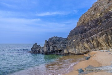 立岩で見た海岸にそびえ立つ柱状節理の奇岩と美しい砂浜の絶景風景