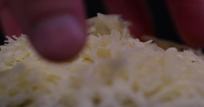 hard ripe cheese grated into small pieces for cooking pasta or pizza, grated piece of yellow cheese as an ingredient for a large dish