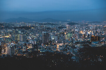 Fototapeta premium Seoul night skyline, South Korea, beautiful aerial twilight view, with mountains and scenery beyond the city, seen from observation deck of Namsan Park, Gyeonggi-do province, Republic of Korea