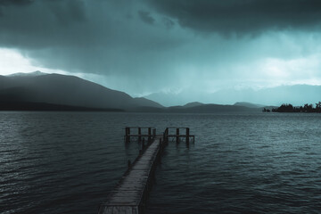 Obraz premium Storm rolling in over pier lake winter dark stormy scene landscape waterscape lake 