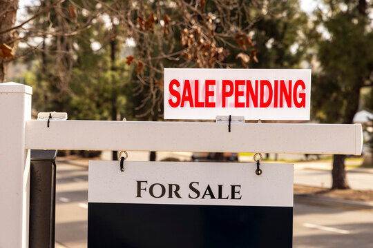 A real estate sign that states Sale Pending on a recently sold residential house