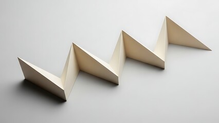 Geometric shapes arranged in a linear progression on a plain white surface viewed from an angle