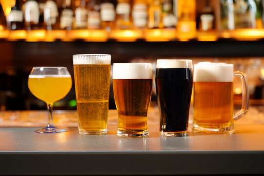 Assorted beer glasses lined up on a bar counter
Beer tasting selection with different styles and colors
Variety of craft beers served in glasses at the bar