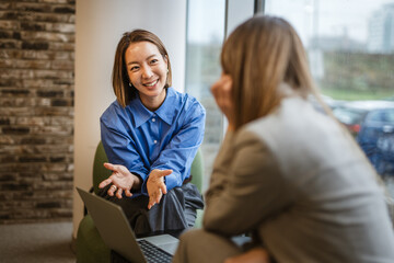 Asian woman smiling during business meeting conversation