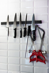 Professional butcher knives organized for steakhouse and meat shop work
Knife set for butcher shop and steakhouse kitchen on magnetic holder
Meat preparation knives stored on wall rack in professional