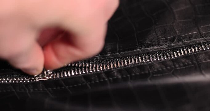 black artificial fabric of crocodile skin with specks and spots, a close-up of a piece of clothing made in the style of leather items made of artificial leather
