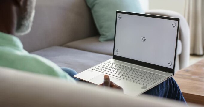 Noticing blank screen, senior man is pointing, hovering near laptop on lap, preparing to type