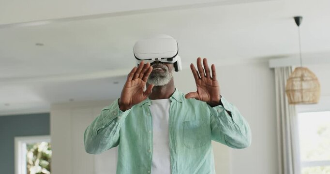 Headset activating, senior man reaching out, pinching, rotating to resize virtual object by window