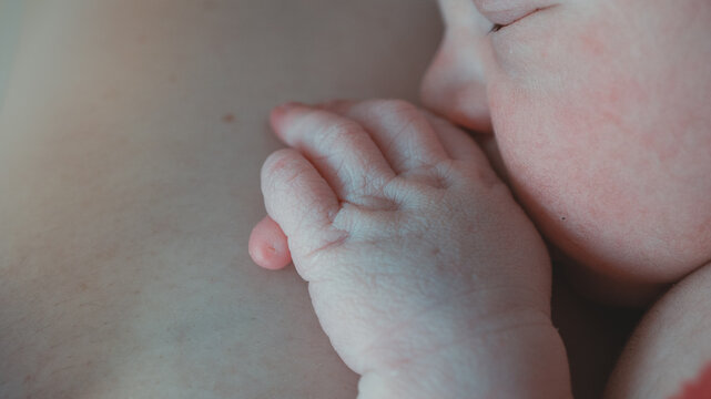 Newborn baby hand with polydactyly in skin-to-skin contact. Intimate and tender image showing a rare physical trait with sensitivity.