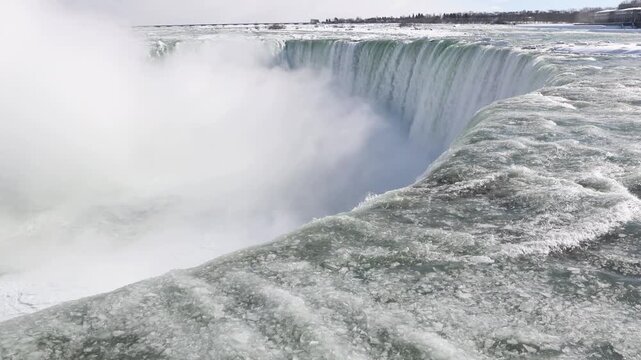 Icy water flowing at the partially frozen Niagara Falls during a polar vortex deep freeze. Ontario Canada side