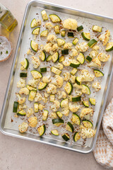 Roasted cauliflower and zucchini with garlic and herbs on a baking sheet