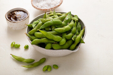 Edamame pods with salt and pepper and a dipping sauce, healthy protein snack