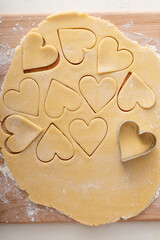 Making heart shaped cookies for Valentines day, cut out vanilla cookies