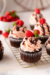 Raspberry chocolate cupcakes with fresh raspberries and chocolate sauce for Valentines Day
