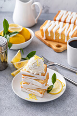 Lemon pound cake with sugar frosting stacked on a plate served with ice cream