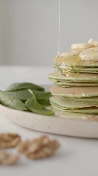 Vegetarian Healthy Meal - Green Spinach Pancakes with Banana and Honey Topping