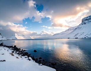 A serene landscape reveals a calm sea embraced by snow-capped mountains under a dynamic sky. Sunlight catches the water