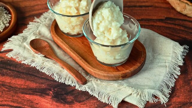 Creamy rice dessert in individual glasses with a wooden spoon