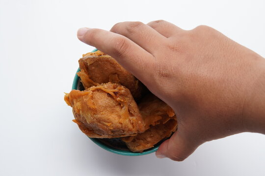 hand holding a piece of tofu. gorengan indonesia tahu isi