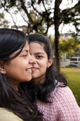 Fototapeta premium Portrait of Two Happy Sisters Smiling Together in Park