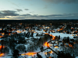 Obraz premium Aerial winter night view of Saint Jerome Quebec with snowy houses and glowing streets at blue hour. g.