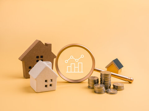 Real estate investment and property analysis concept with various houses, magnifying glass, chart icon, and coins stacks. Financial due diligence, asset growth, and housing market trends concept.