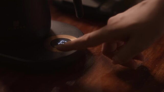 Close up hand of  woman setting the temperature on an electric kettle.