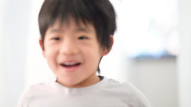 カーテンの隙間から走ってくる無邪気な子どもの動画スローモーション