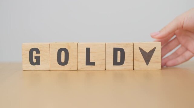 Hand change wood cube block with GOLD text to UP and Down arrow symbol icon.price, down and up, decrease and increase, cut loss, stocks, financial and economic concept