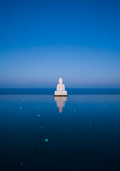 Serene White Buddha Statue Meditation by Infinity Pool Reflecting Clear Blue Sky at Dusk, Zen Tranquility