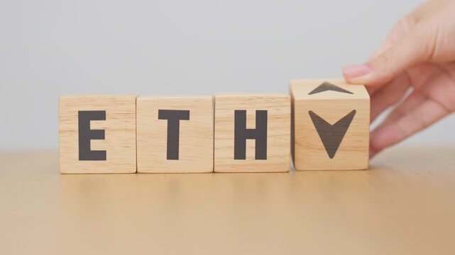 Hand change Wooden block with ETH or Ethereum text to UP and Down arrow symbol. cryptocurrency, blockchain, price, down and up, decrease and increase, cut loss, trade and financial concepts
