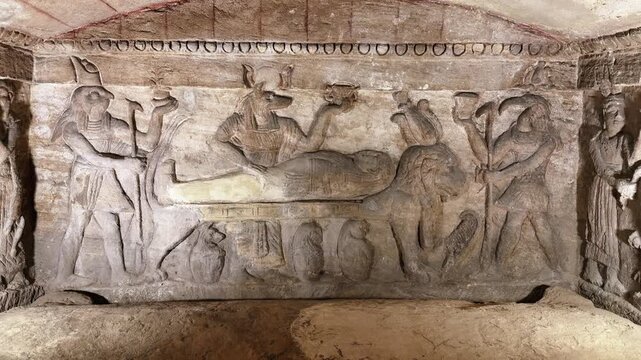Tilt down shot of main burial chamber with carved sarcophagus inside the Catacombs of Kom el Shoqafa