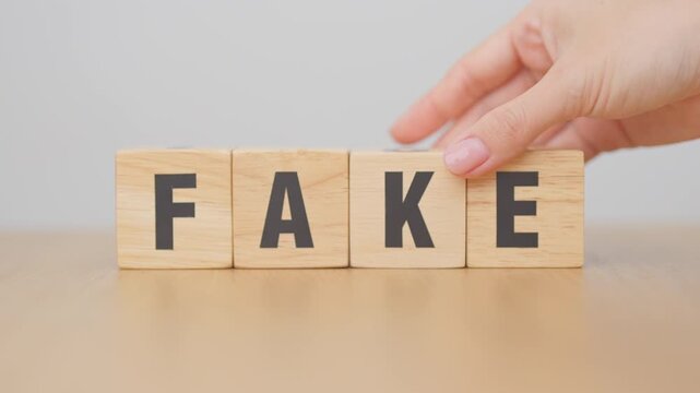hand change wooden block FAKE to FACT. rumor News, false, myth, evidence and disinformation concepts