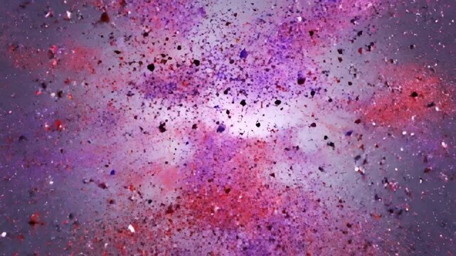 Abstract explosion of colorful particles in reds and purples, emanating from a bright core