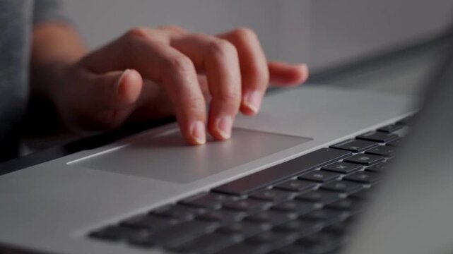 Close-up of Hands Navigating Laptop Trackpad and Typing in Bright Modern Office. Work from home or freelancing concept. 