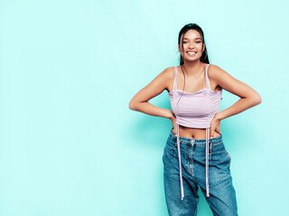 Young beautiful smiling female in trendy summer jeans and top clothes. Carefree woman posing near...