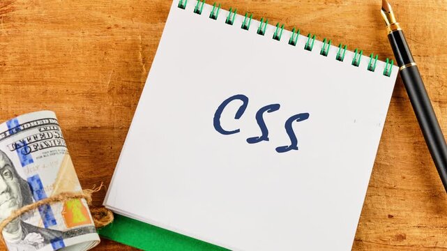 A close up view details the progression of writing the letters CSS. Faint outlines become clearer and darker on a notepad, moving to bold blue ink