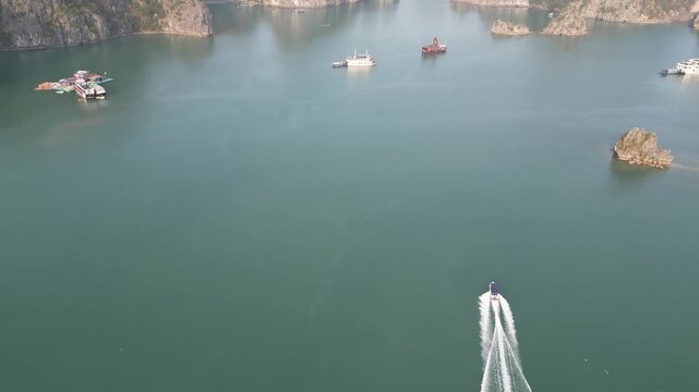 Aerial view of limestone karst mountains and cruise ships navigating the waters of Ha Long Bay near Cat Ba Island, Vietnam.