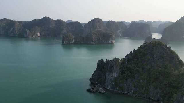 Aerial view of limestone karst mountains and cruise ships navigating the waters of Ha Long Bay near Cat Ba Island, Vietnam.