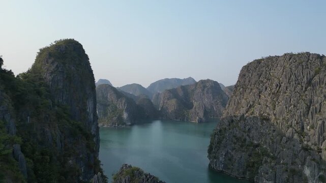 Aerial view of limestone karst mountains and cruise ships navigating the waters of Ha Long Bay near Cat Ba Island, Vietnam.