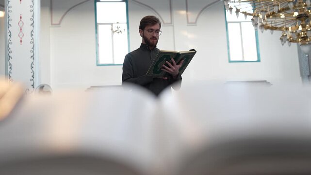 Muslim young man reading Holy Quran in mosque during Ramadan. Peaceful worship during the holy month of fasting. Ramadan atmosphere. the concepts of religion.