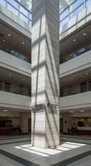 Obraz premium Modern Multi-story Building Interior with Central Concrete Column and Natural Light