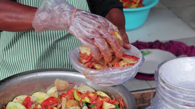 Indonesian street food vendor serving fresh fruit rujak in plastic bowl with natural light for culinary concept