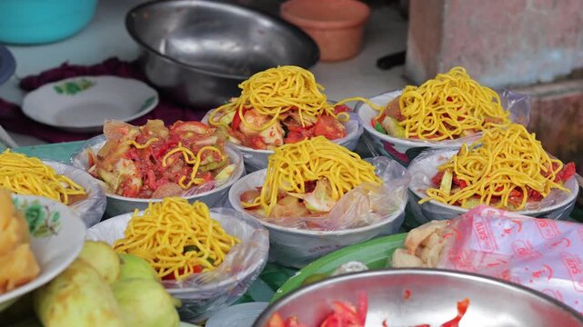 Indonesian street food snacks in bowls with yellow noodles under natural light for culinary concept