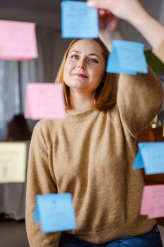 Woman placing inspirational sticky notes on mirror for well being