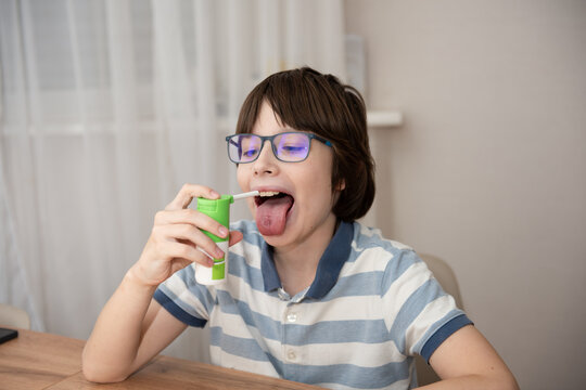 A boy with the flu using a medical spray