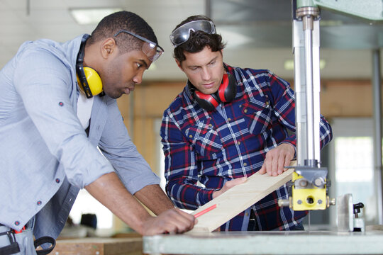 2 workers men cutting metal in two pieces