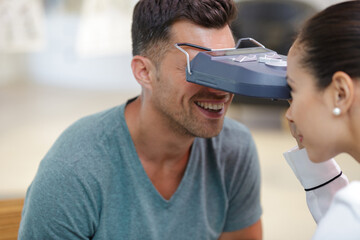 ophthalmologist using handheld device to inspect patients eyes © auremar